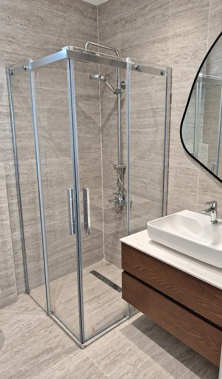 Banyo tadilatı sonrası gri taş desenli seramikli duş alanı ve lavabo dolabı