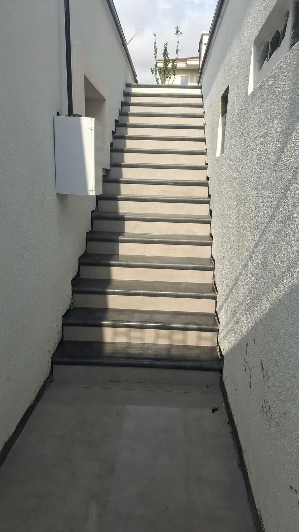 Açık renk seramikle kaplanmış merdivenin alt sahanlıktan görünümü
