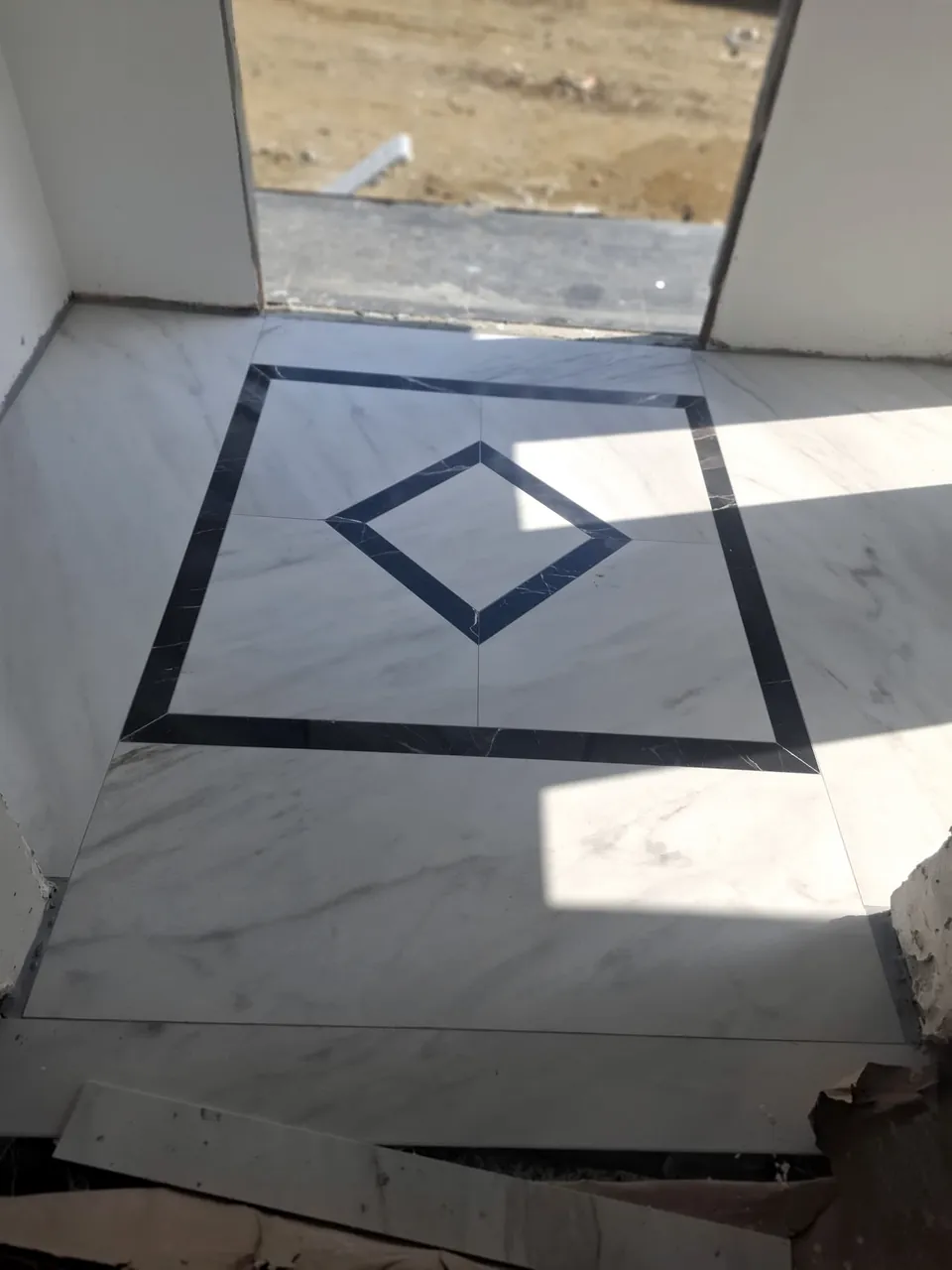 Koyu bordür ve elmas biçimli merkez desenli parlak seramik zemin